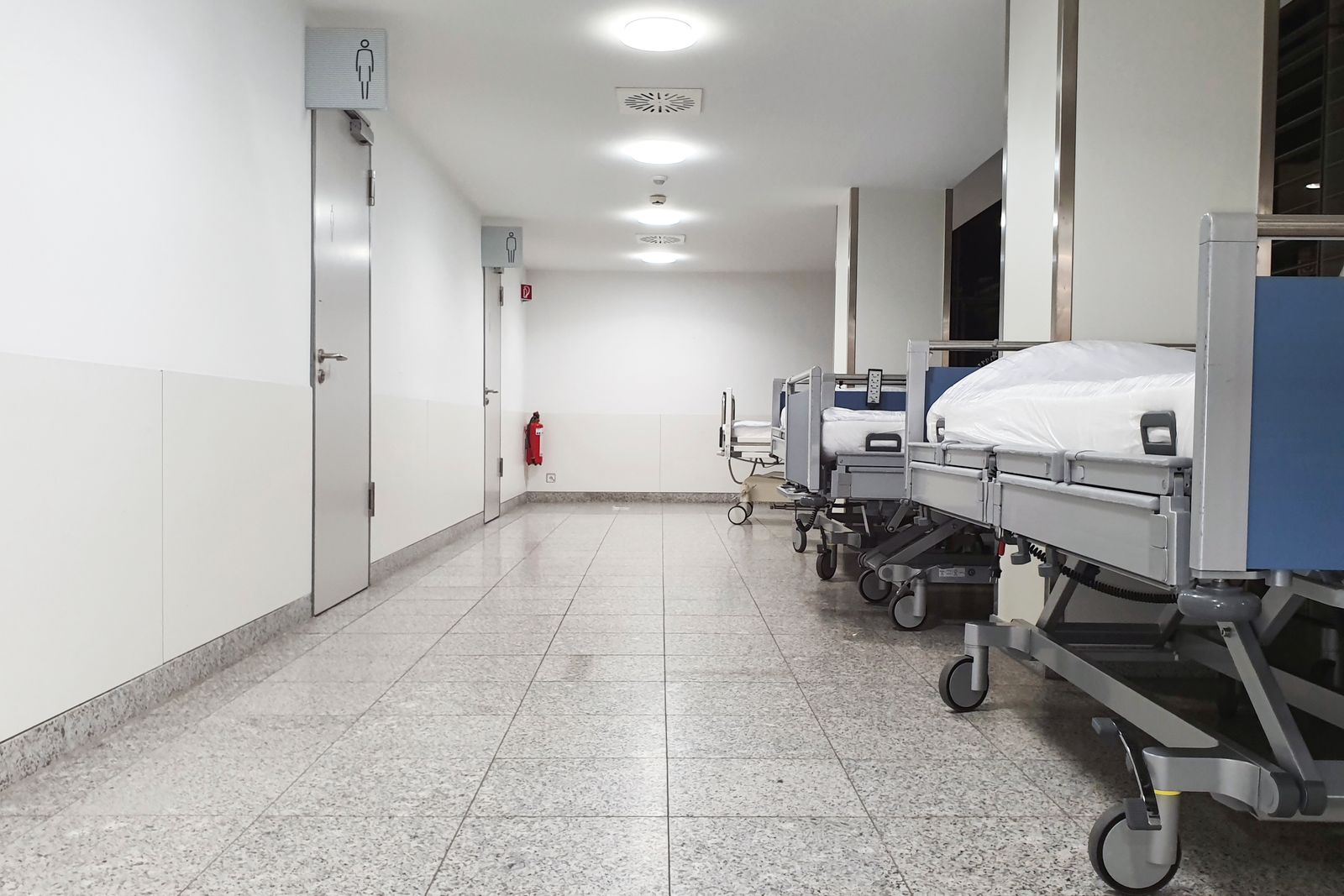 A hospital corridor lined with beds.